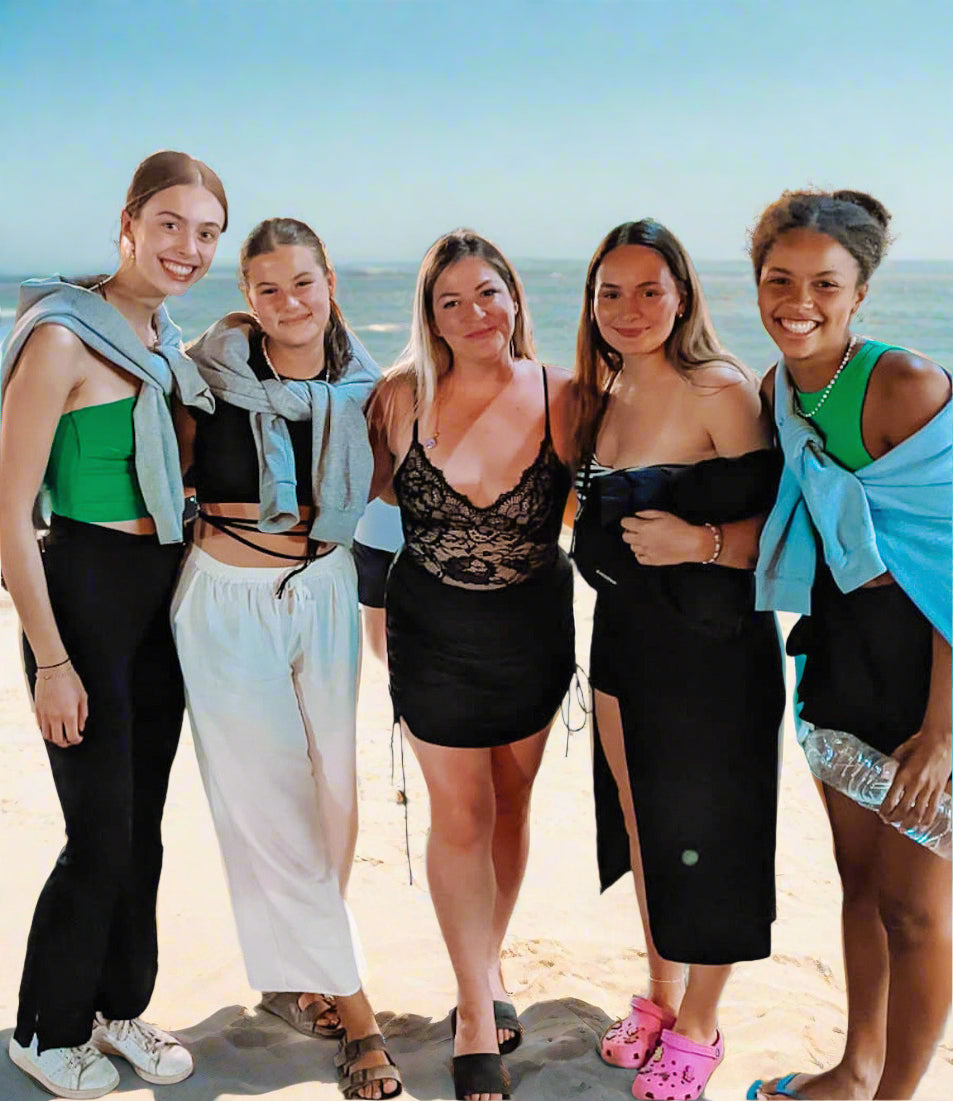 Five women posing together outdoors, with a casual and friendly atmosphere.