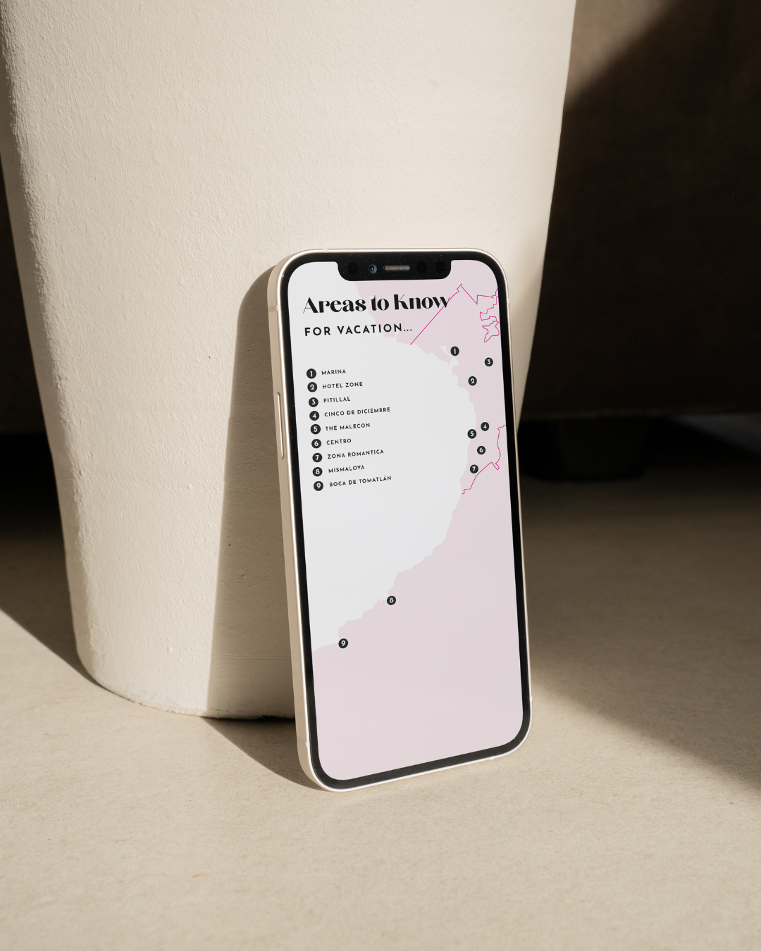 Phone displaying a list of areas to know for vacation on a beige background