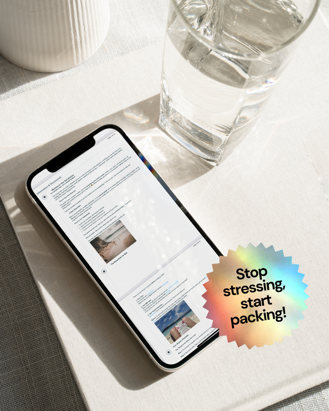 Phone with a travel app open on a table next to a glass of water