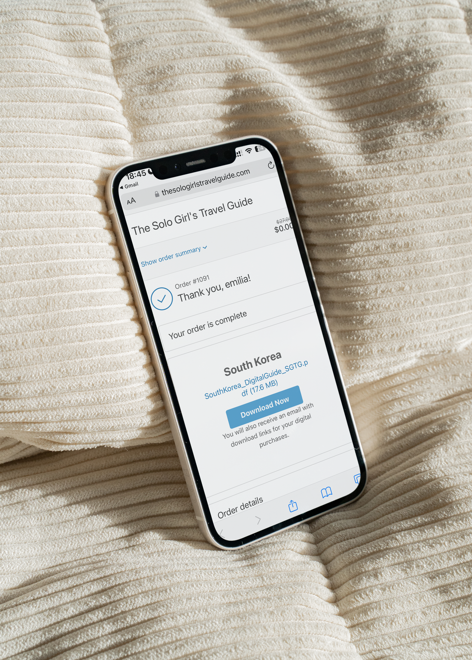 Phone displaying a travel guide app on a textured beige surface