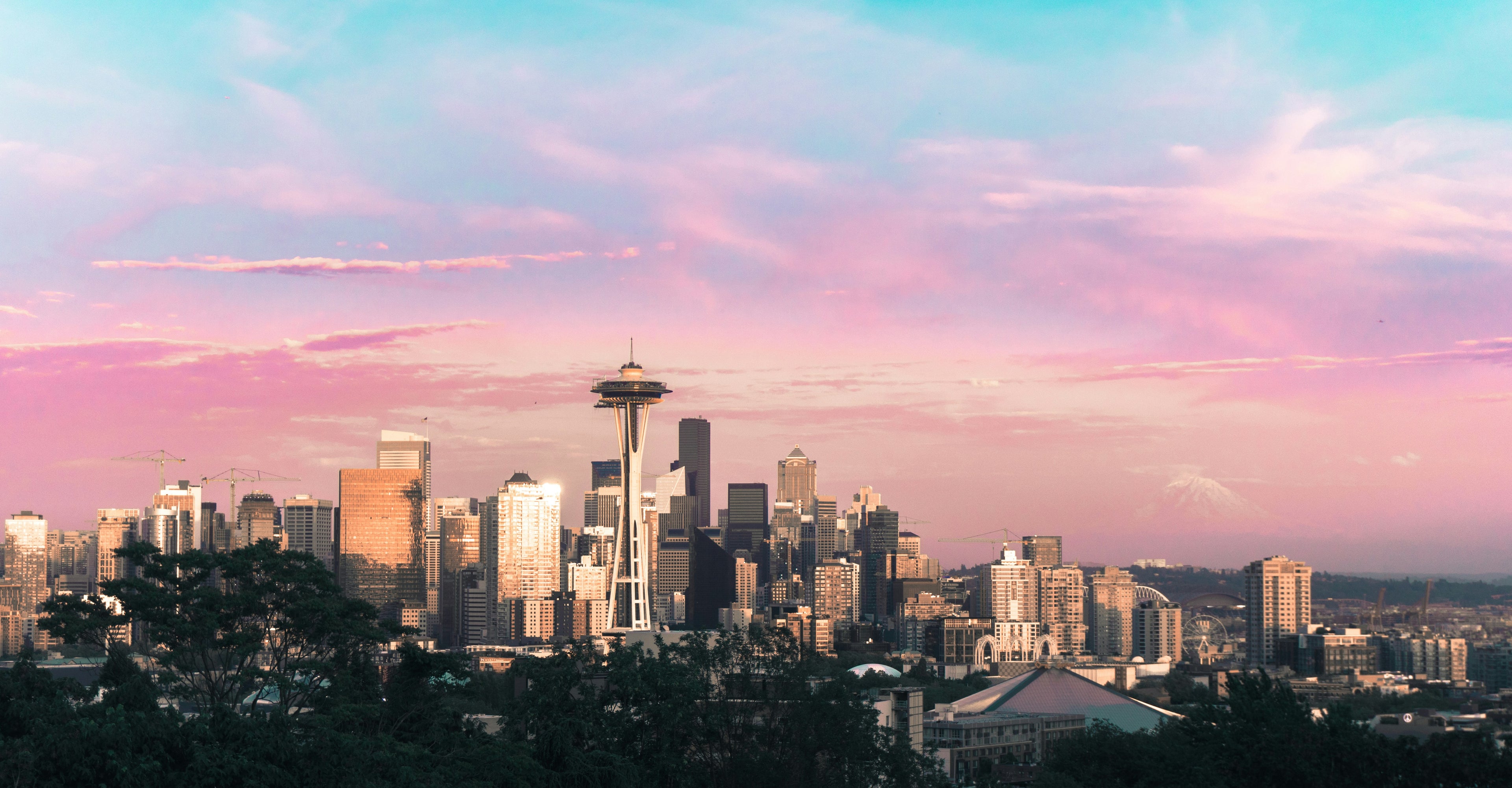 City skyline with a distinctive tower under a pastel-colored sky