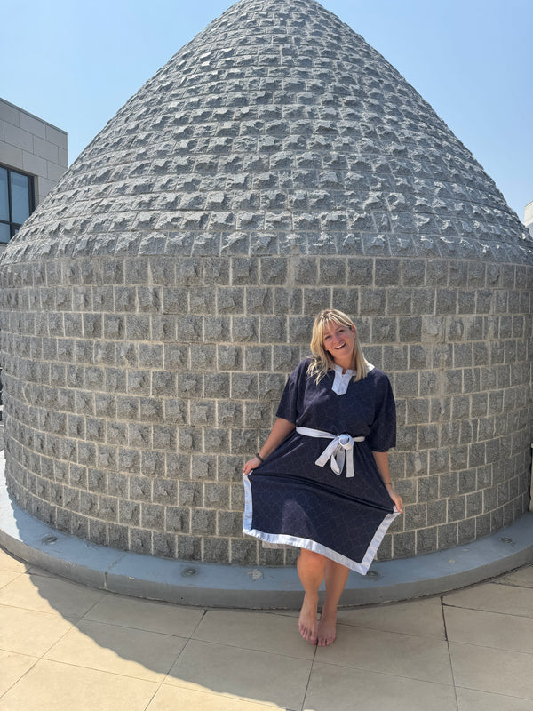 Person standing on a circular stone platform with a modern building in the background