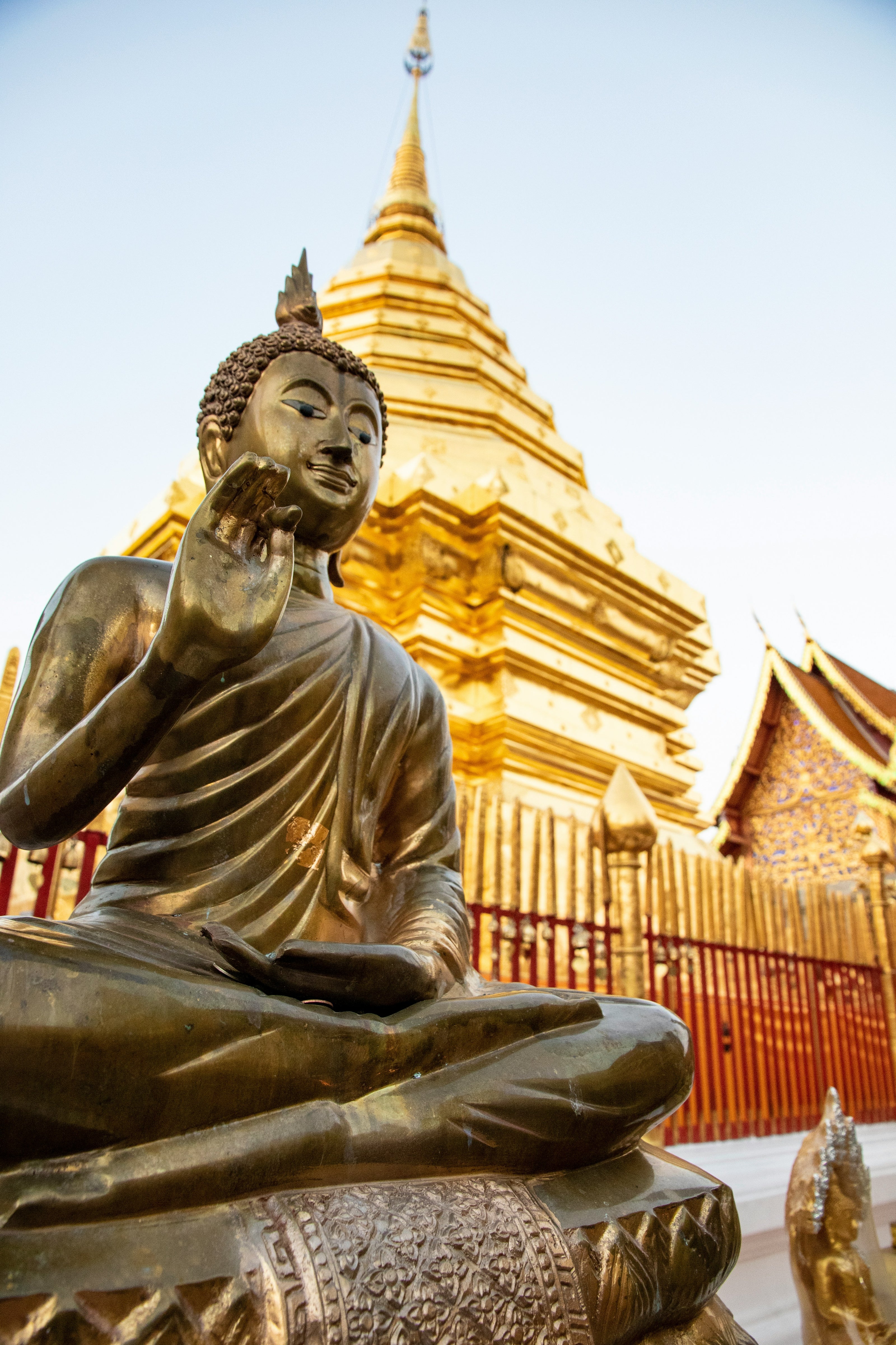 Bronze Buddha statue in front of a golden temple