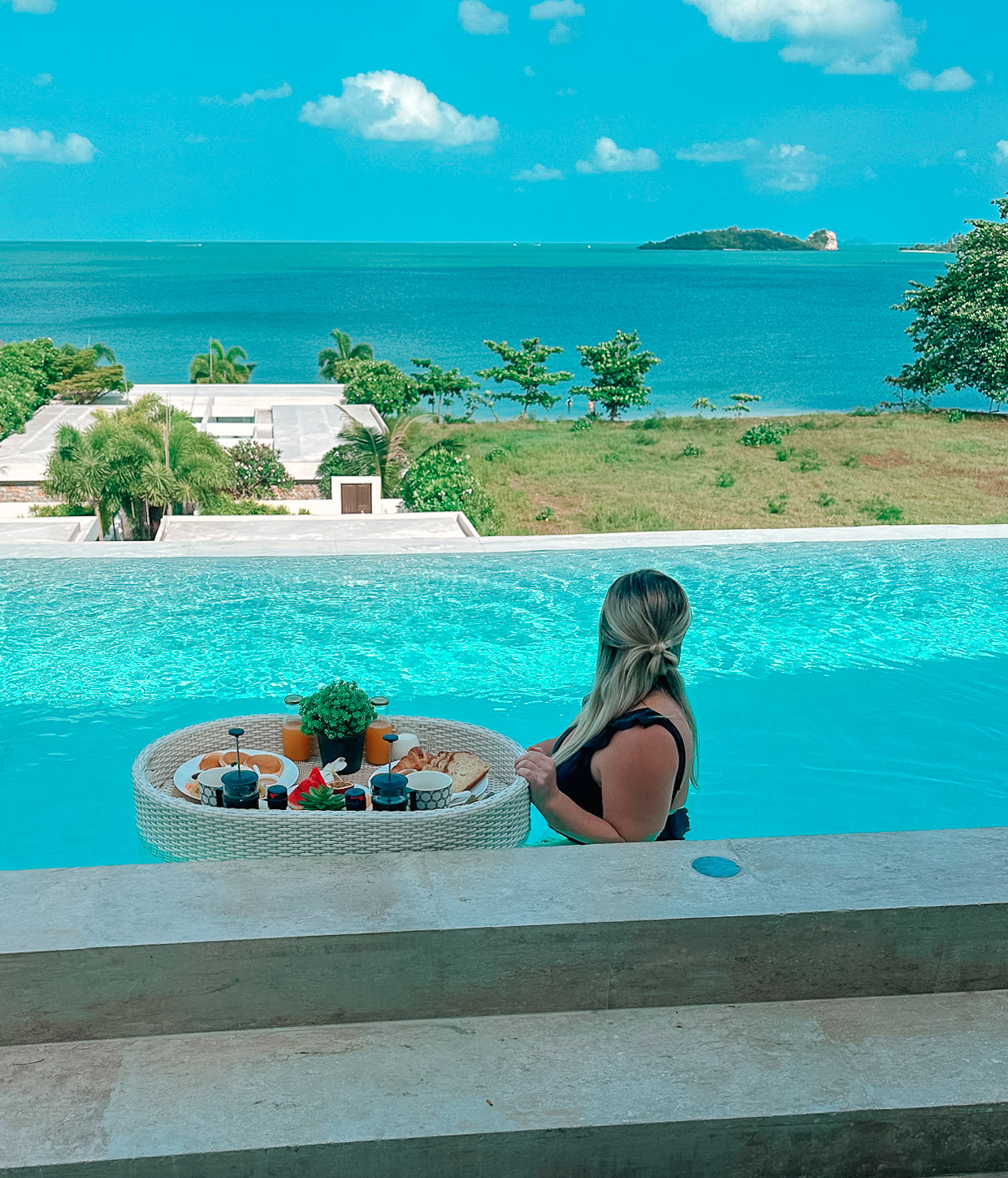 girl having a floating breakfast in a pool in a beach in thailand