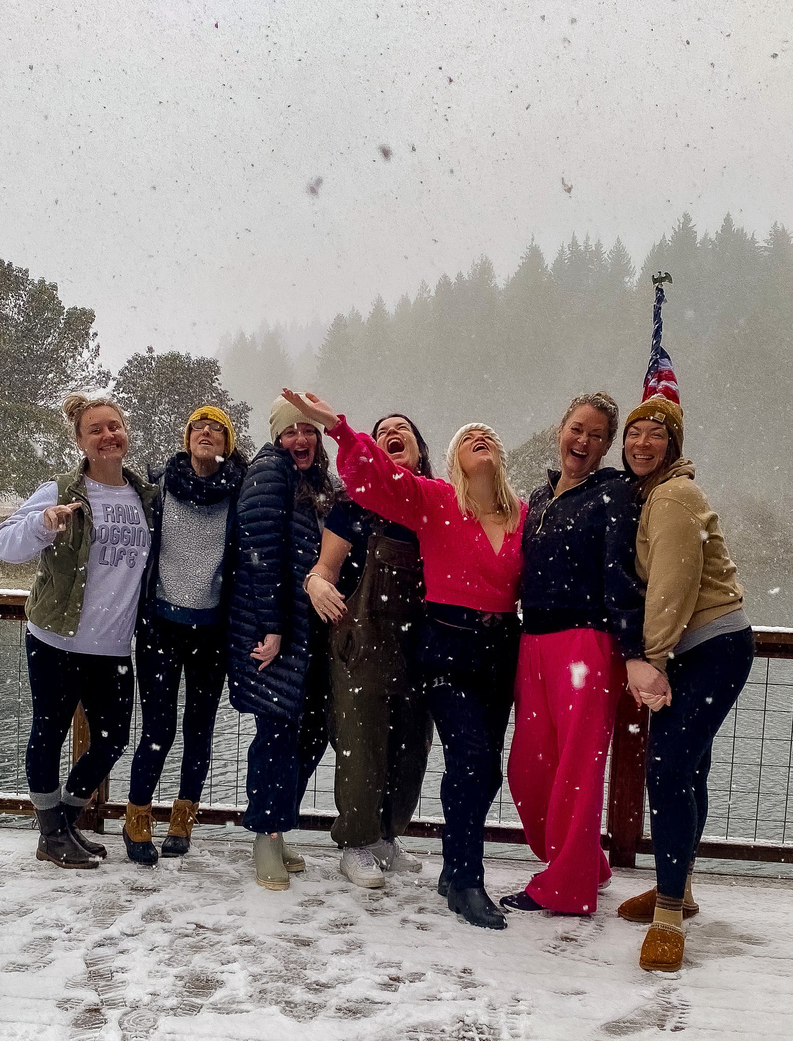 Group of people posing in the snow with a scenic background